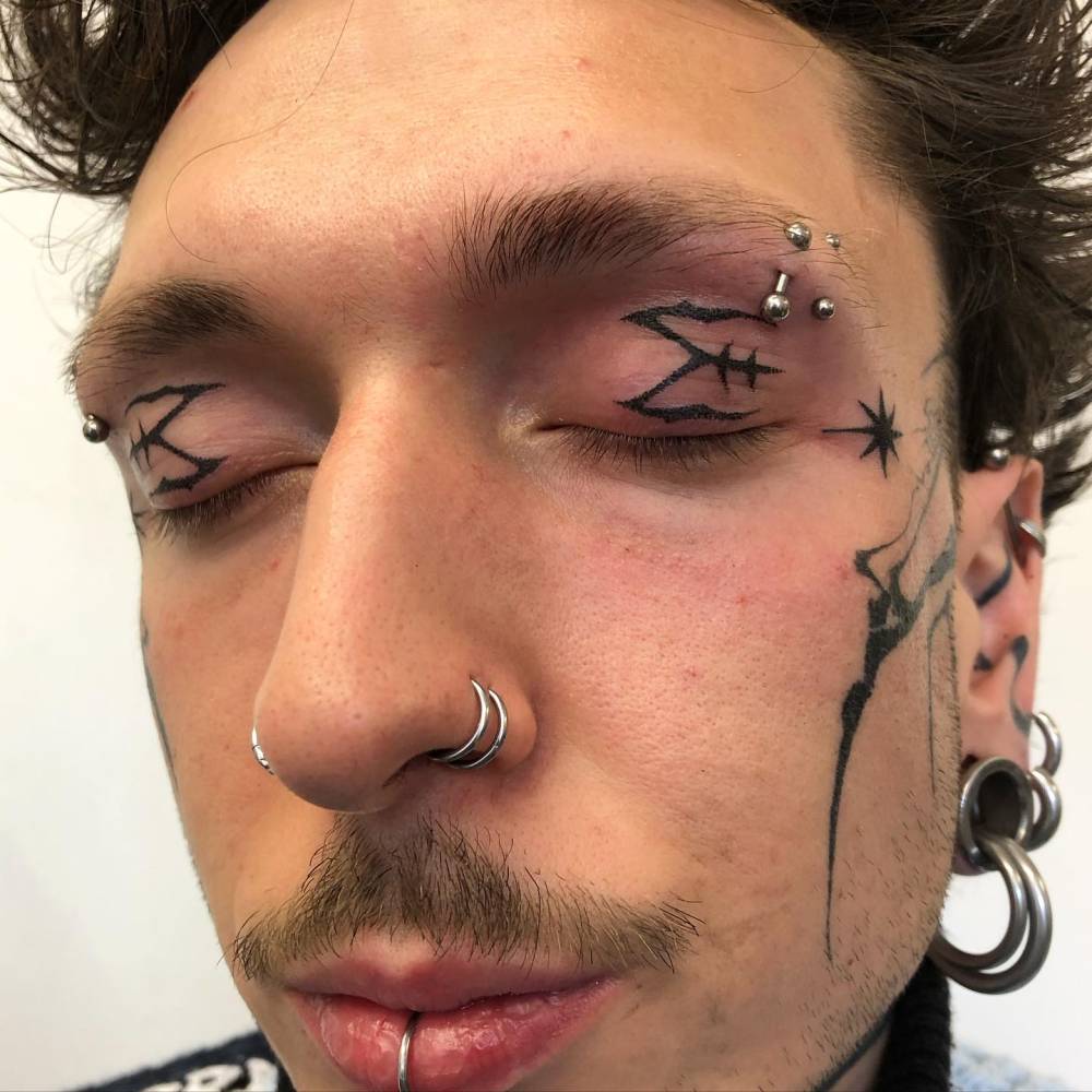 Hand poked tribal tattoos located on the eyelids.