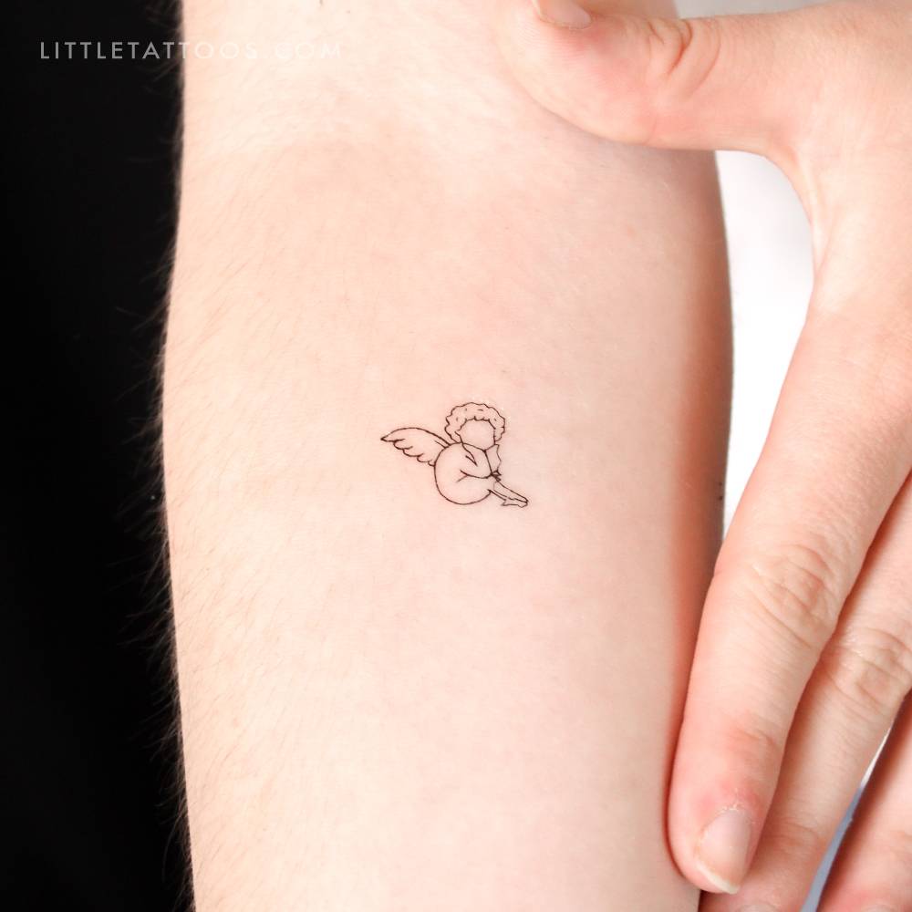 Faceless cherub temporary tattoo located on the inner forearm.