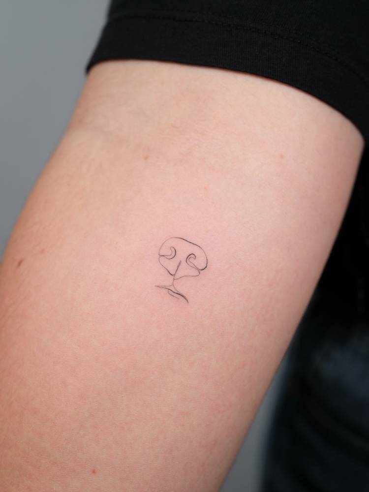 Continuous line dog snout tattoo located on the inner forearm.