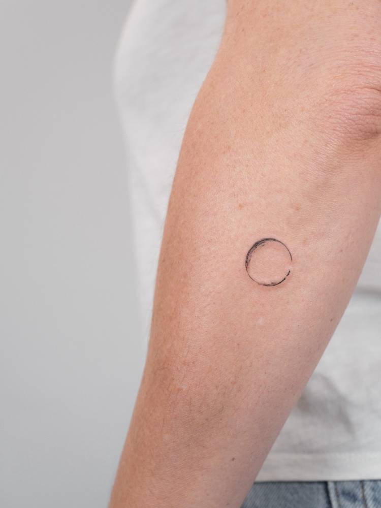 Enso tattoo located on the forearm, watercolor style.