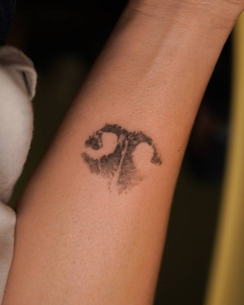 Dog snout tattoo in watercolor style located on the inner forearm.