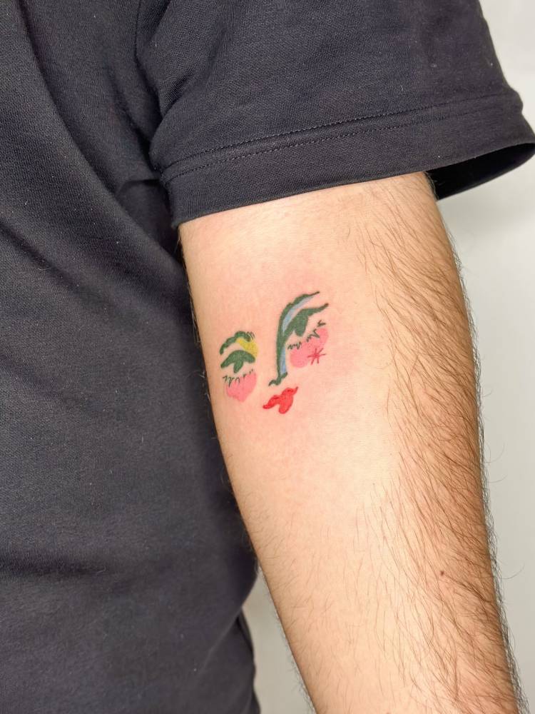 Illustrative style face tattoo located on the inner forearm.