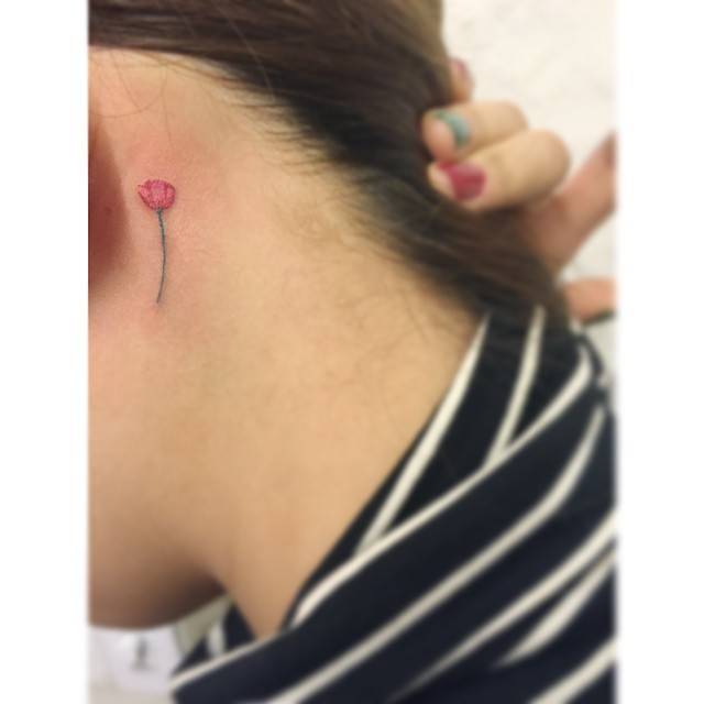 Tulip tattoo in minimalist style located behind the ear.
