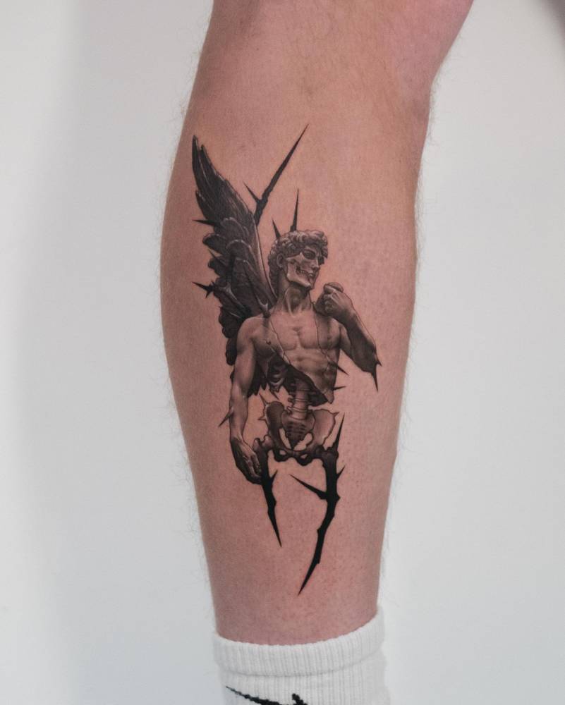 David as a fallen angel tattooed on the shin, micro-realistic style.