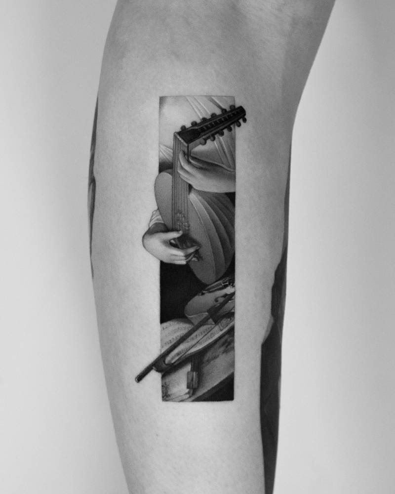 'The Lute Player' tattoo located on the inner forearm.