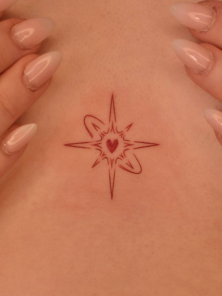 Red star heart tattooed on the sternum, fine line style.