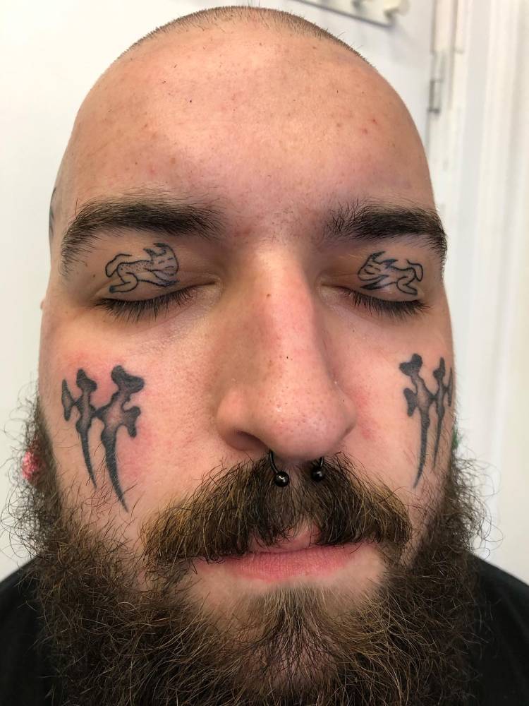 Hand poked little demons tattooed on the eyelids.