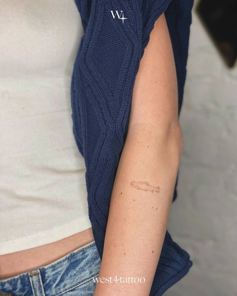 Salmon tattoo in fine line style located on the forearm.