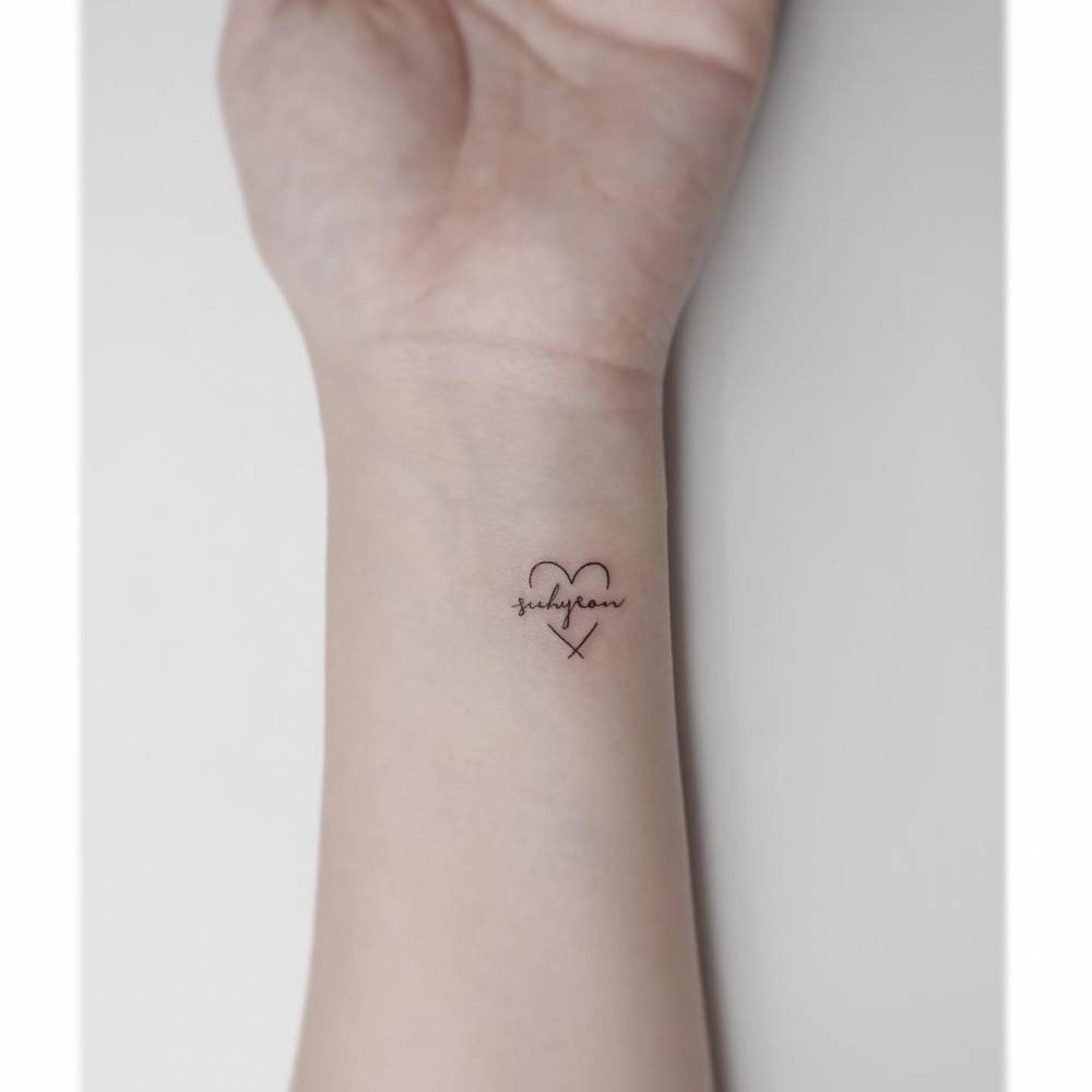Heart and banner tattoo in minimalistic style located on the wrist.