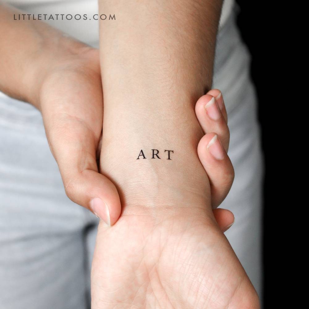 Serif font word 'ART' temporary tattoo located on the wrist.