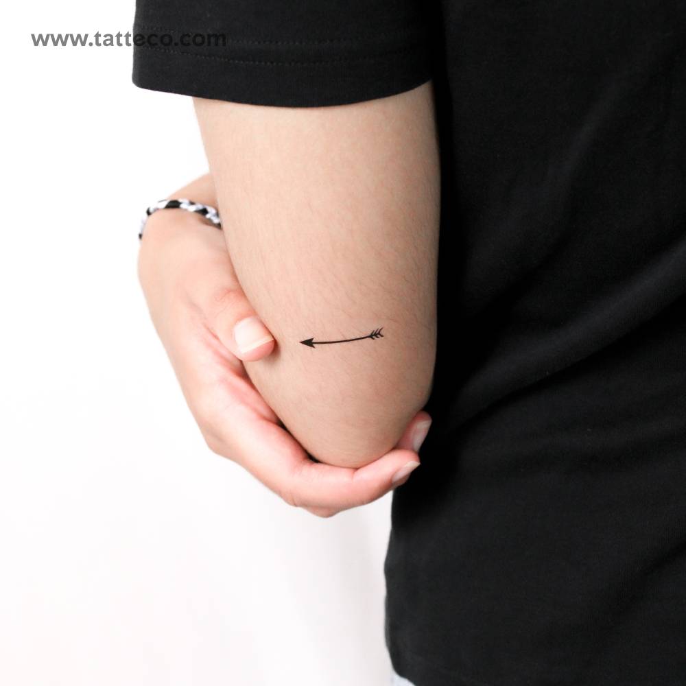 Arrow temporary tattoo in minimalistic style placed on the tricep.