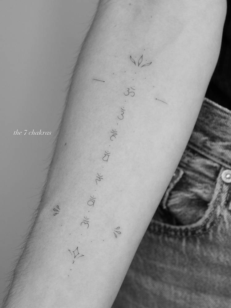 Sanskrit lettering tattoo located on the inner forearm.