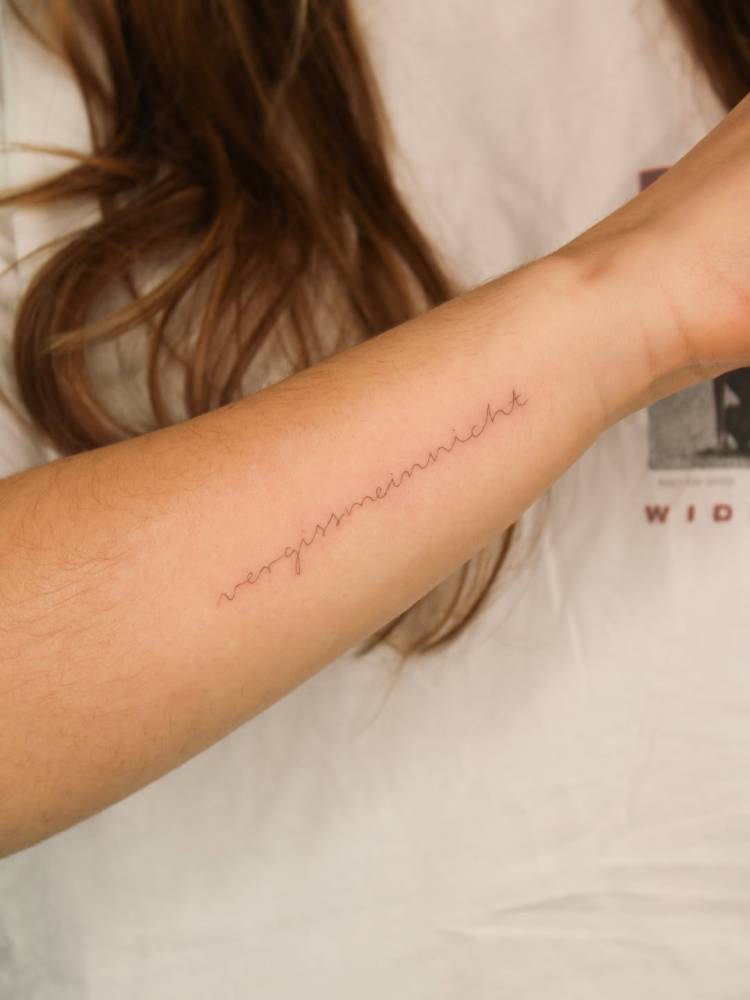 "Vergissmeinnicht" lettering tattoo in handwritten font.