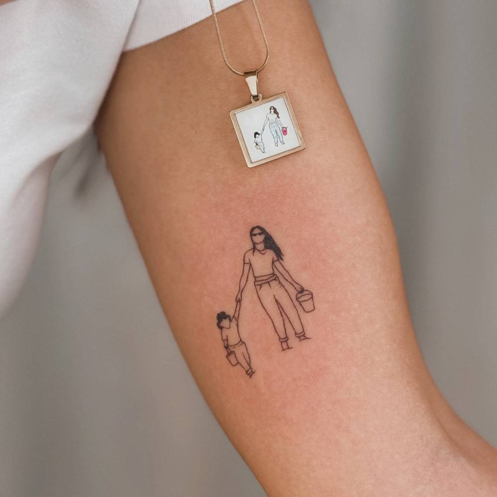 Motherhood tattoo in illustrative style located on the inner arm.