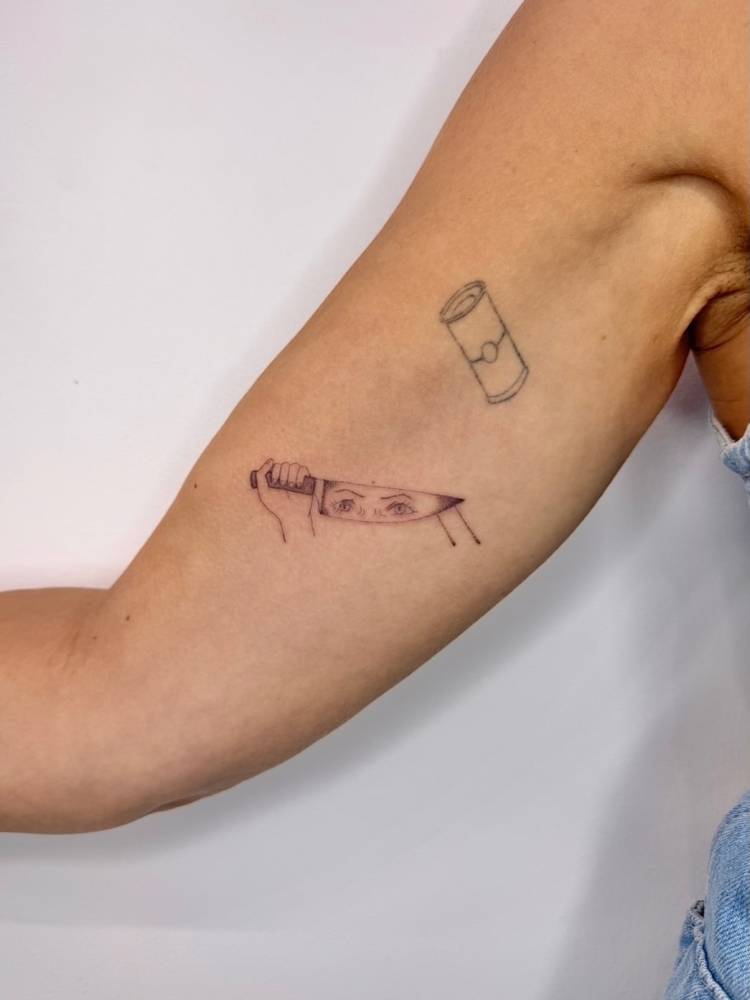 Single needle knife and eyes tattoo located on the inner arm.