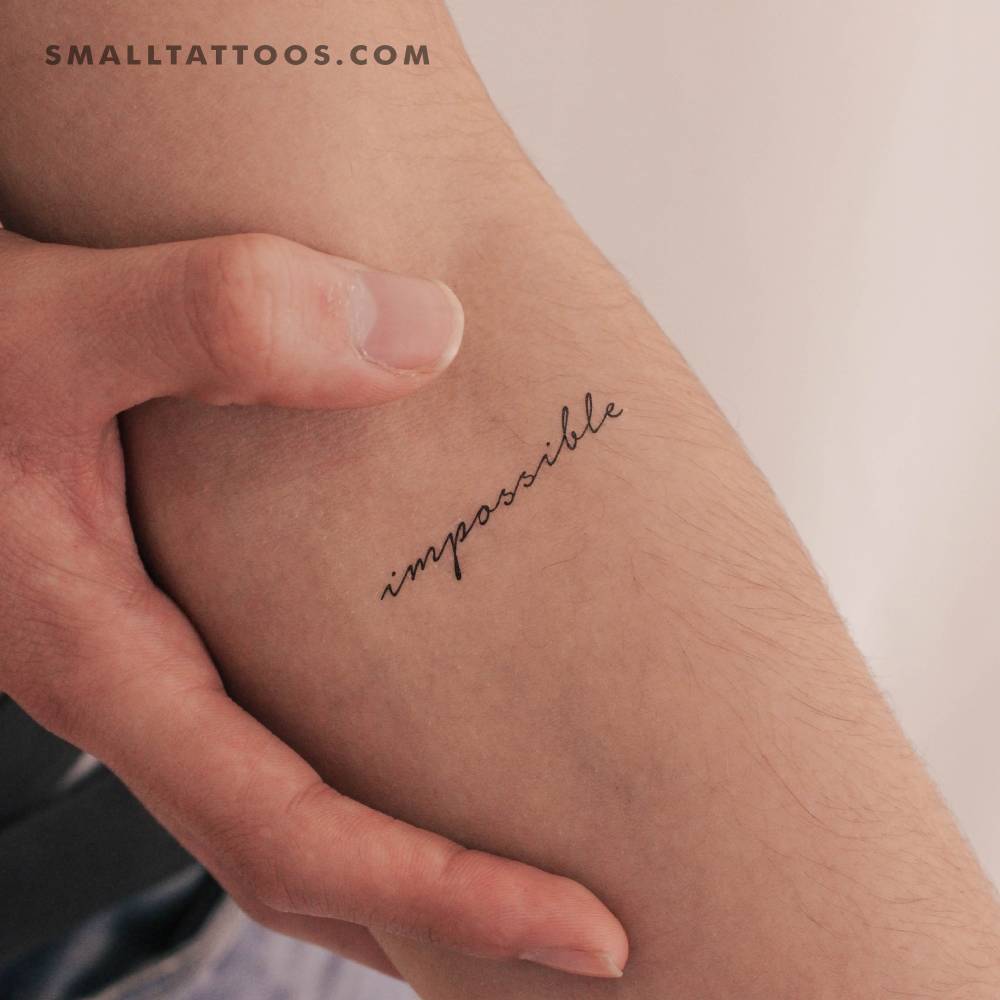 Word "impossible" temporary tattoo located on the inner forearm.