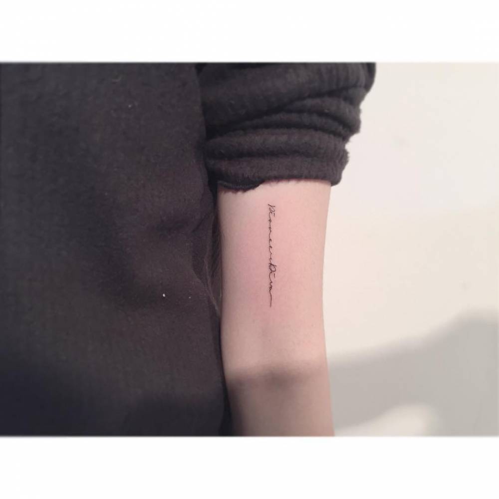 Handwritten font lettering tattoo located on the bicep.