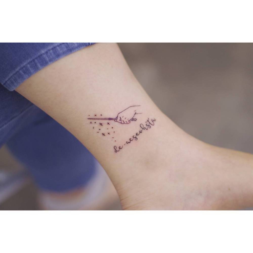 Magic wand tattoo in fine line style located on the ankle.