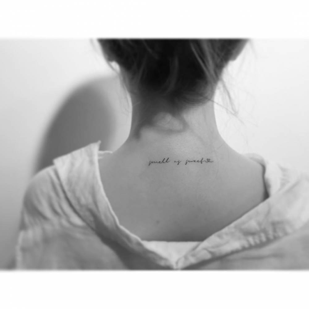 “Smell as sweet” lettering tattoo located on the upper back.