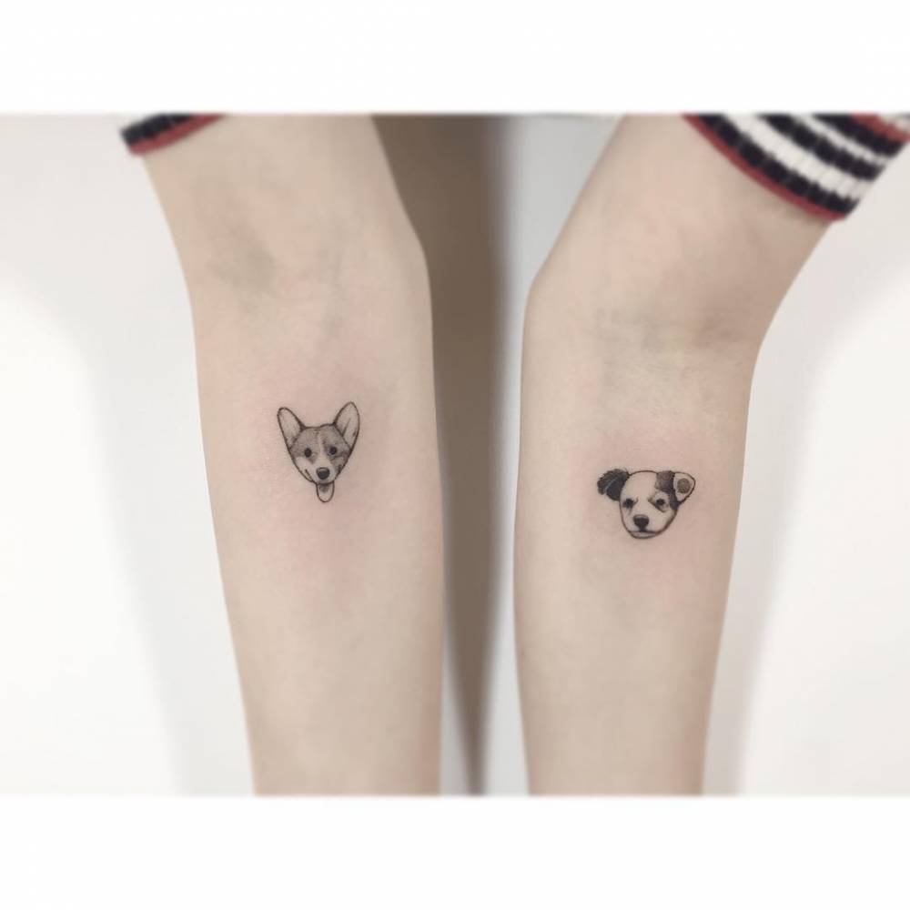Illustrative style dog portraits tattooed on the inner forearms.