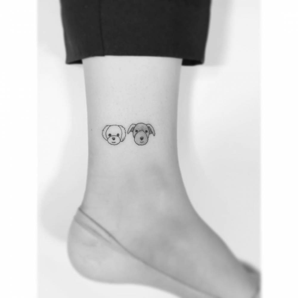 Illustrative style dog portraits tattooed on the ankle.