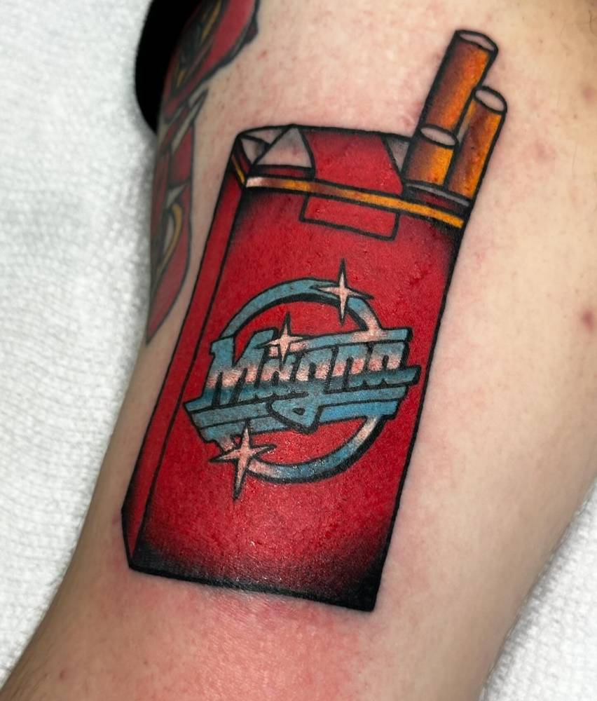 Magna Cigarettes tattooed on the inner arm, traditional style.