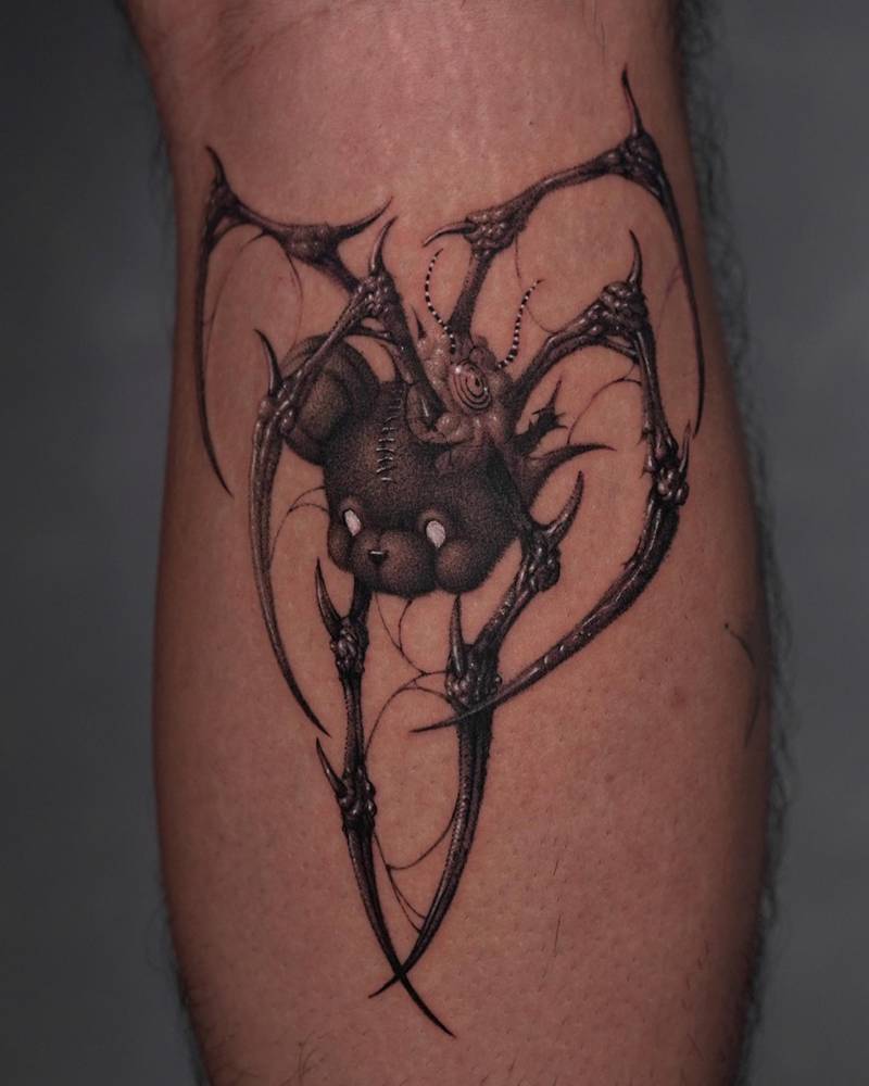 Monstrous teddy bear tattoo located on the calf, comic style.