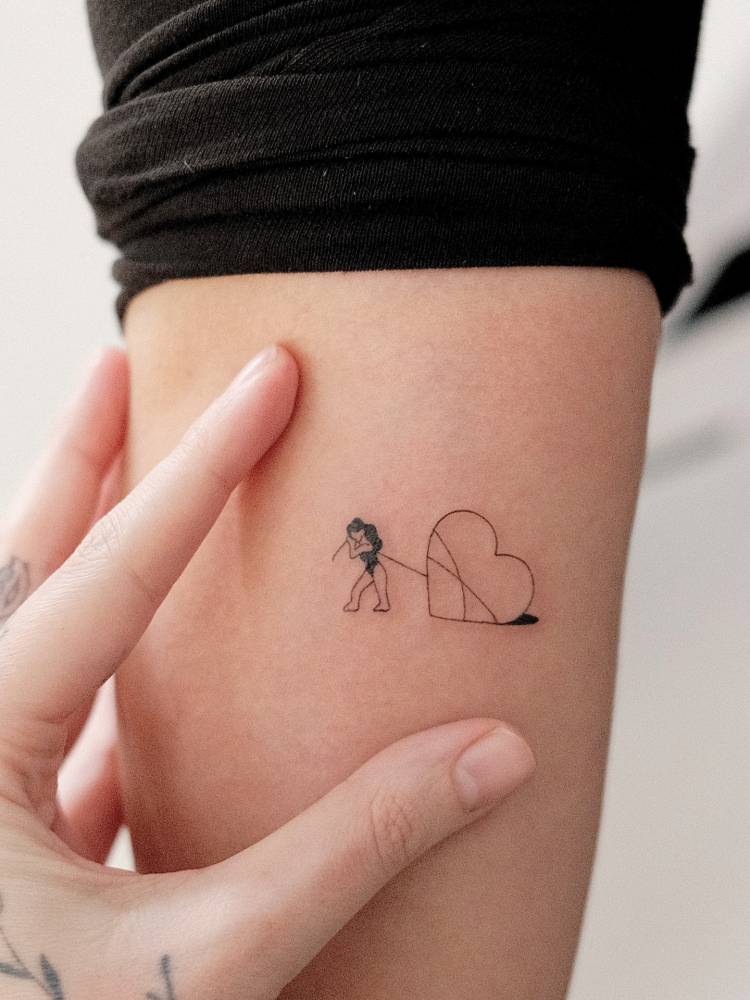 Dragging a heart tattooed on the inner forearm, minimalistic style.