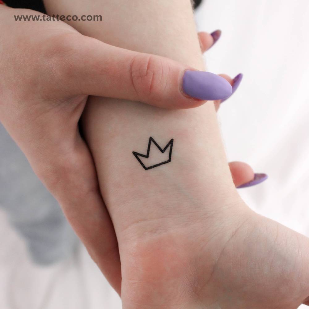 Small minimalist crown temporary tattoo located on the wrist.