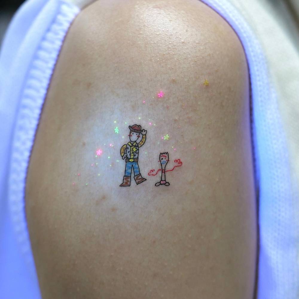 Woody and Forky tattoo located on the upper arm.