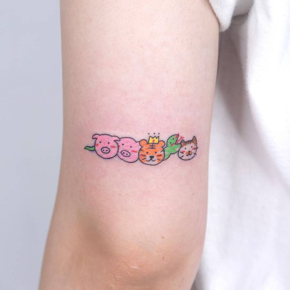 Cute animals tattoo in cartoon style located on the tricep.