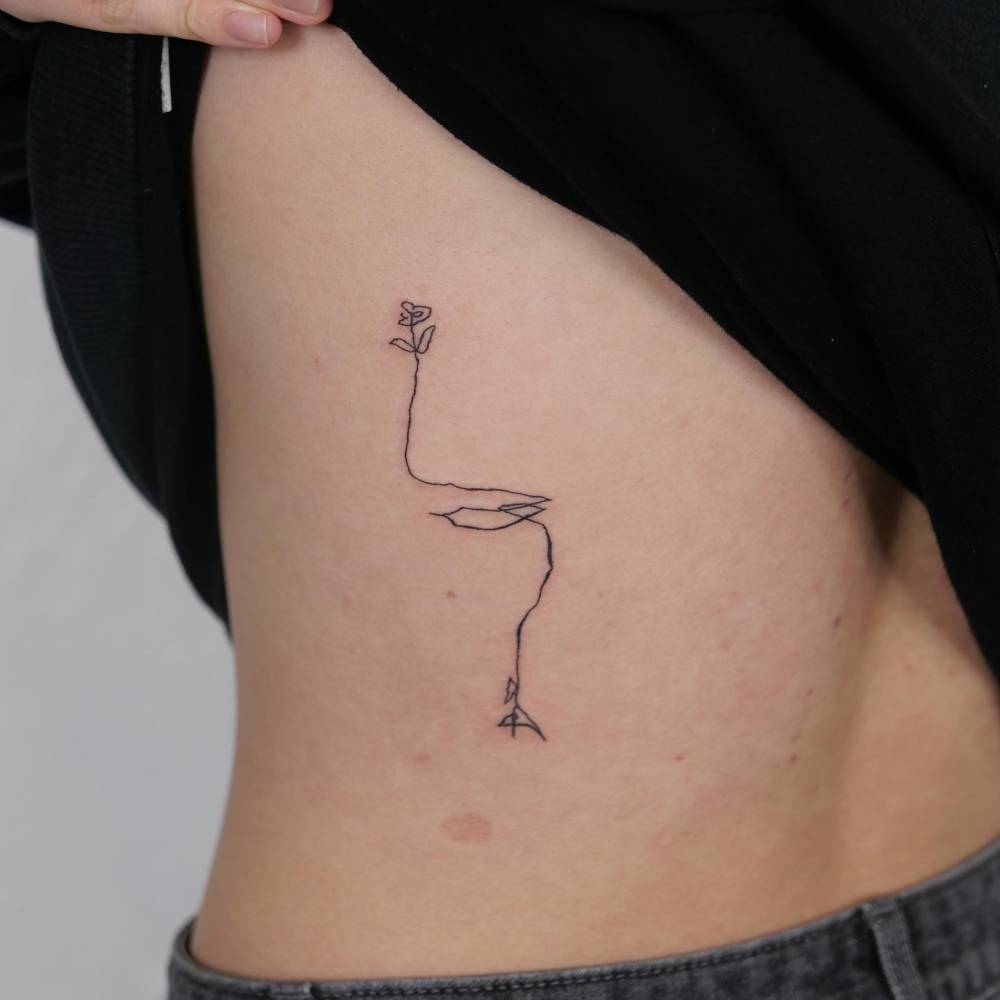 Sketch work style flower tattoo located on the back.