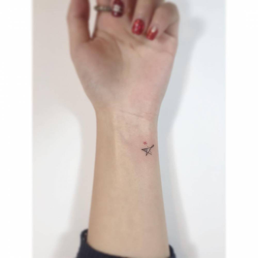 Star tattoo in minimalistic style located on the wrist.