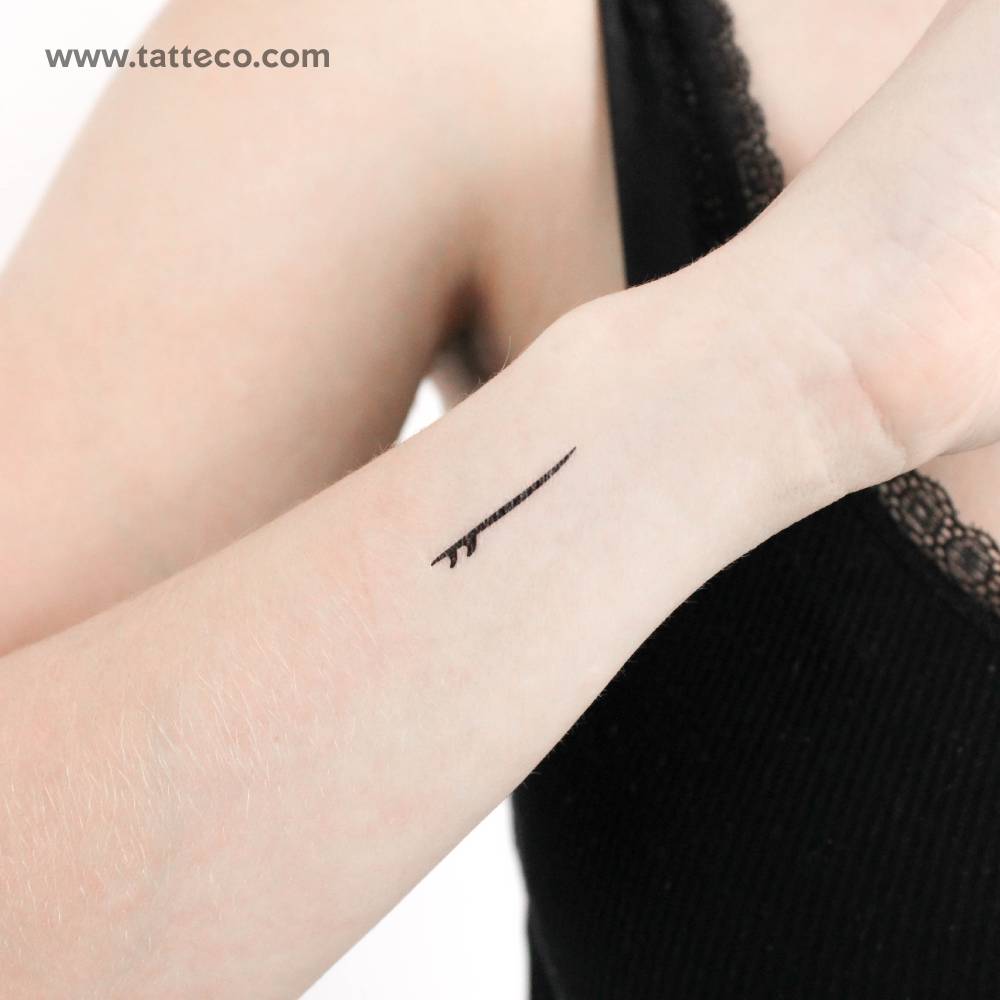 Little minimalist surfboard temporary tattoo located on the wrist.
