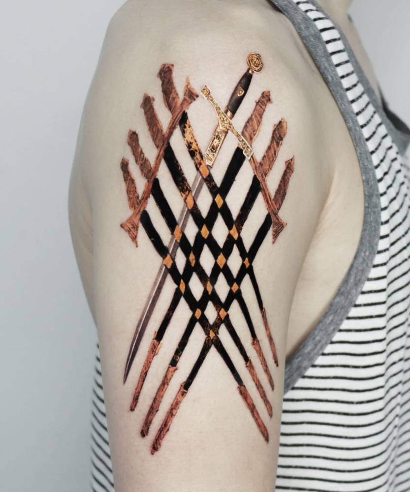 The Eight of Swords Tarot Card tattooed on the upper arm.