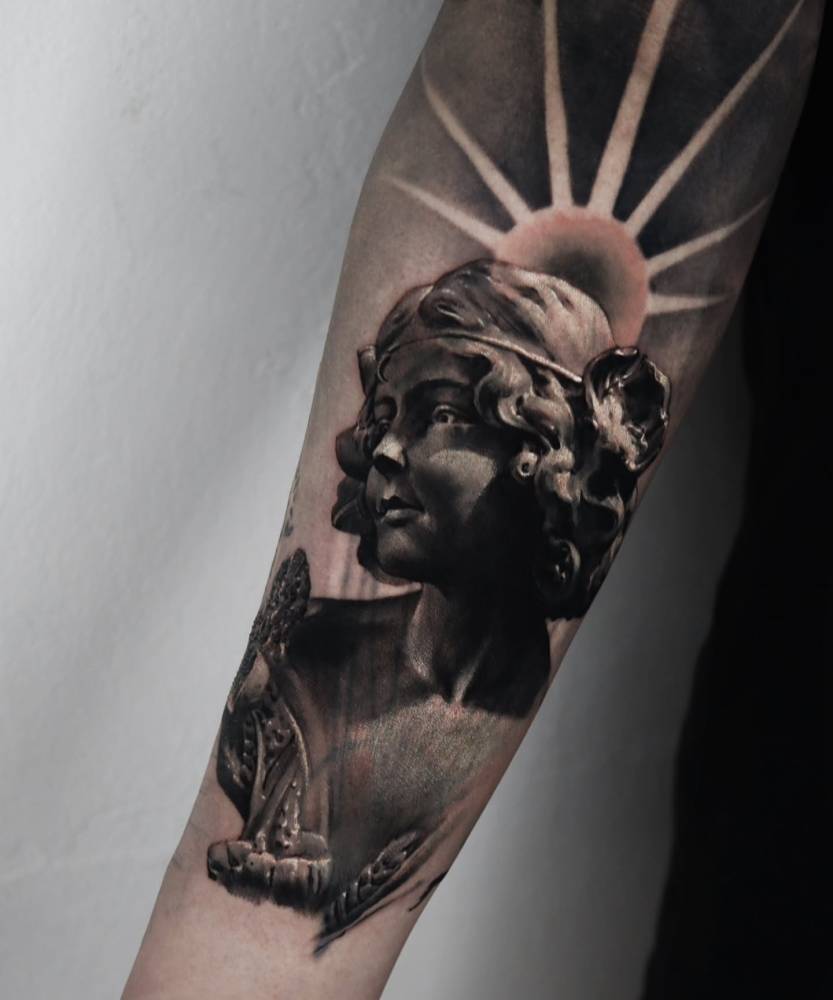 Sculpture tattoo located on the inner forearm, black and grey style.