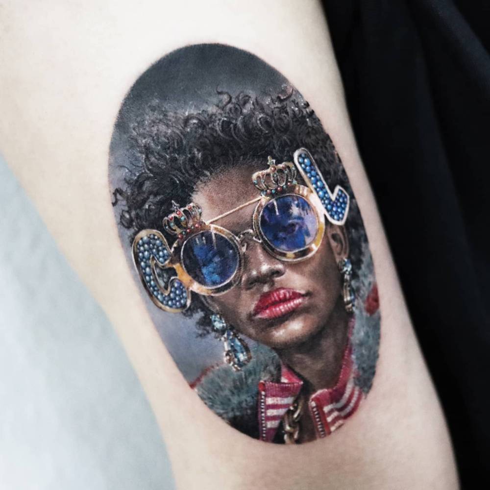 Woman wearing "cool" sunglasses tattooed on the tricep.