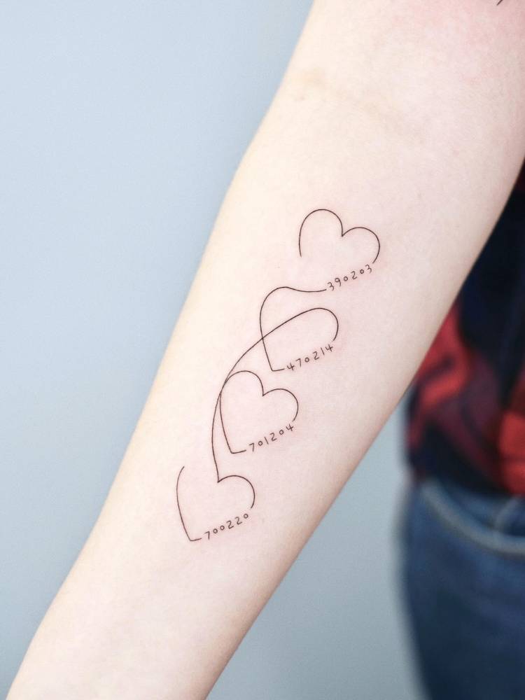 Hearts and dates tattoo placed on the inner forearm.