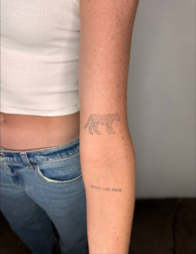 Healed single needle leopard tattoo located on the bicep.