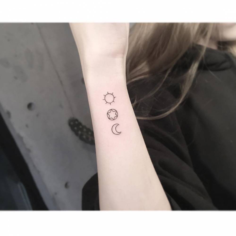 Sun, star and moon tattoo in minimalistic style done on the wrist.