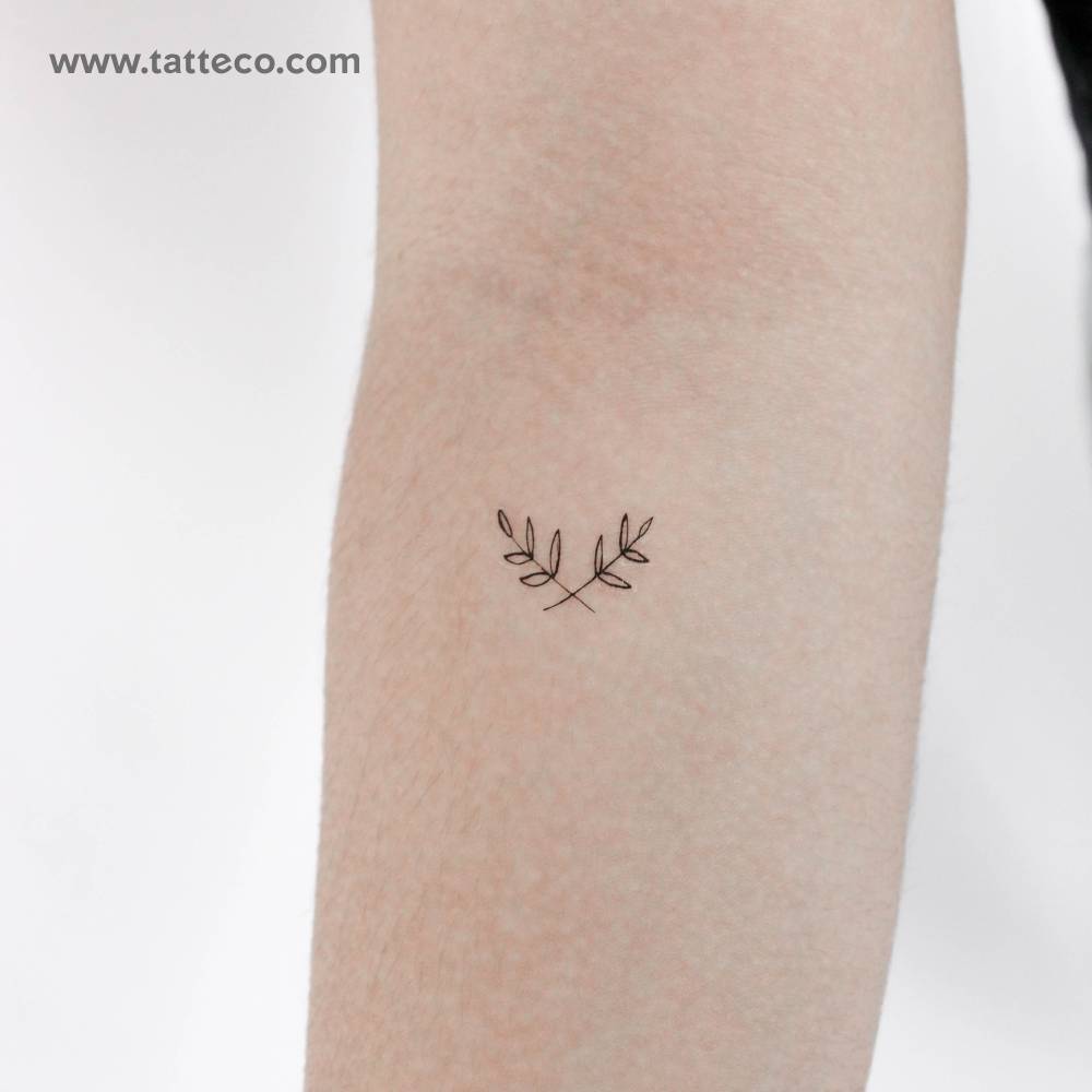 Fine line style laurel wreath temporary tattoo located on the inner forearm.