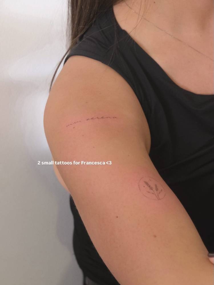 "Vivi serena" and lavender tattoos located on the upper arm and shoulder.