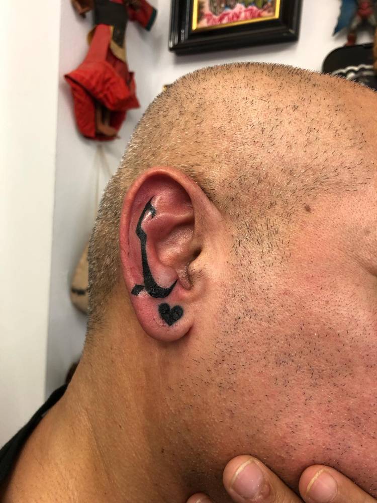 Hand poked abstract design tattooed on the ear.