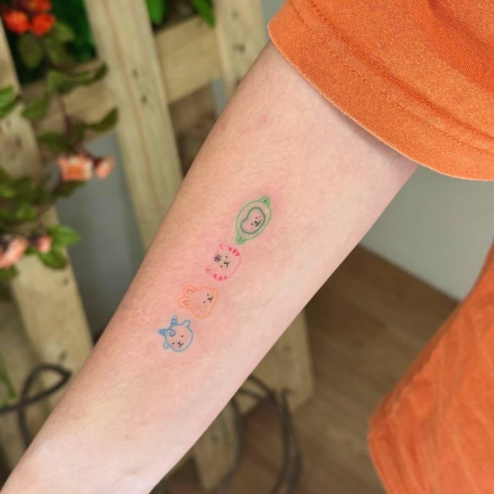 Cartoon style little animal friends tattooed on the inner forearm.