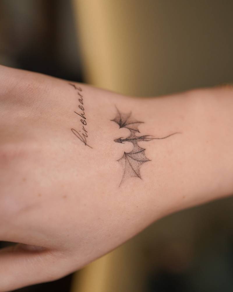 Dotwork style dragon tattoo located on the wrist.