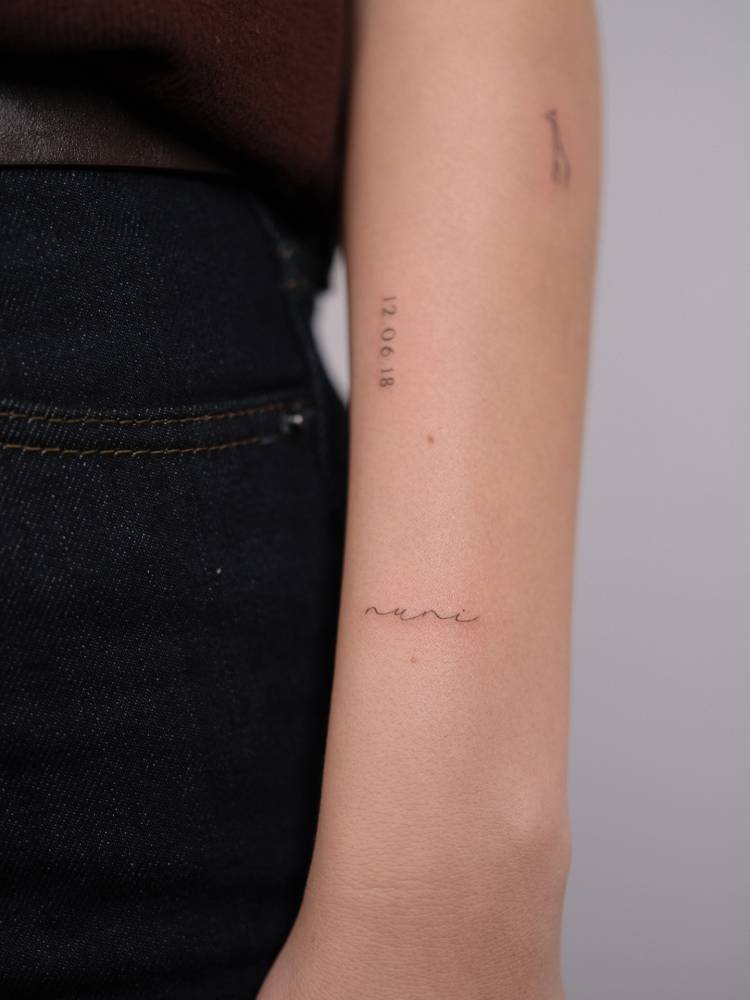 Handwritten font name "Nuni" tattooed on the wrist.