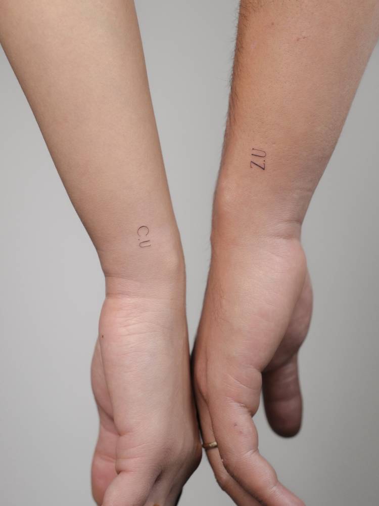 Matching little initials tattoo for couple.