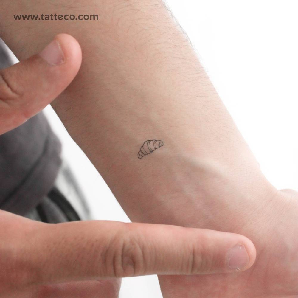 Tiny croissant temporary tattoo in minimalist style.
