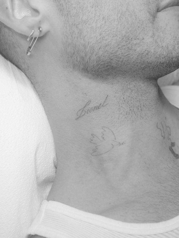 Script font name "Lionel" tattooed on the neck.
