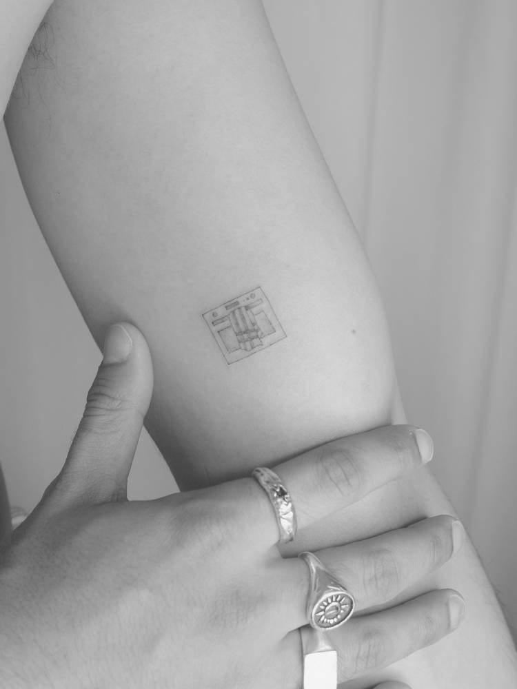 Little oven tattoo in fine line style located on the inner arm.